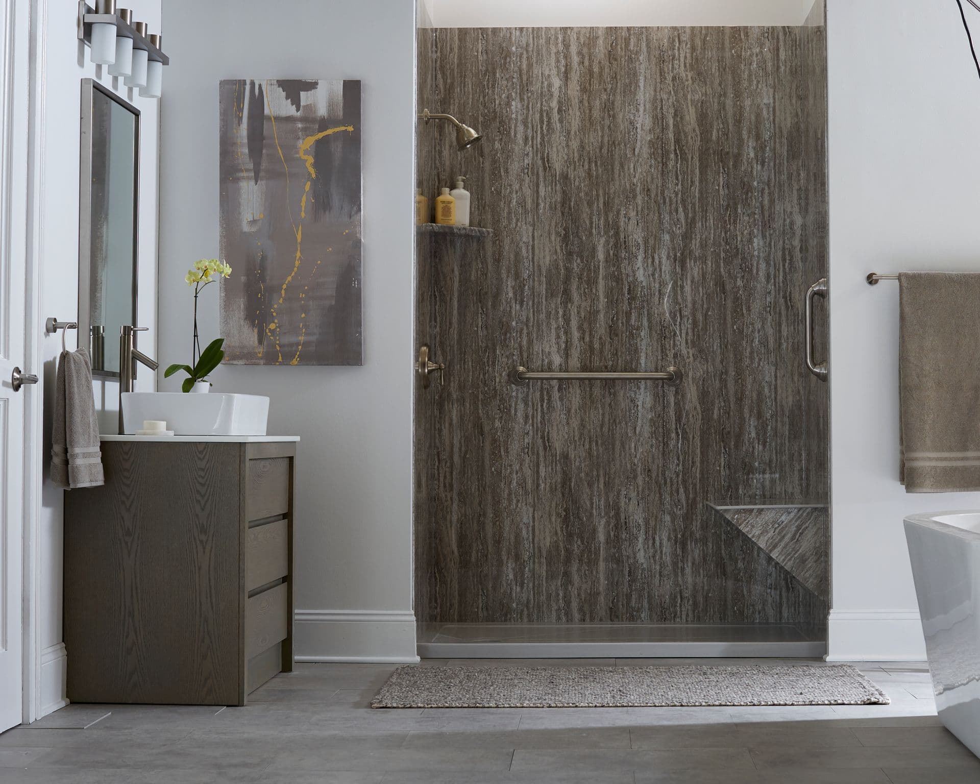 A walk-in shower with brown, stone textured walls, built-in bench, and grab bars.