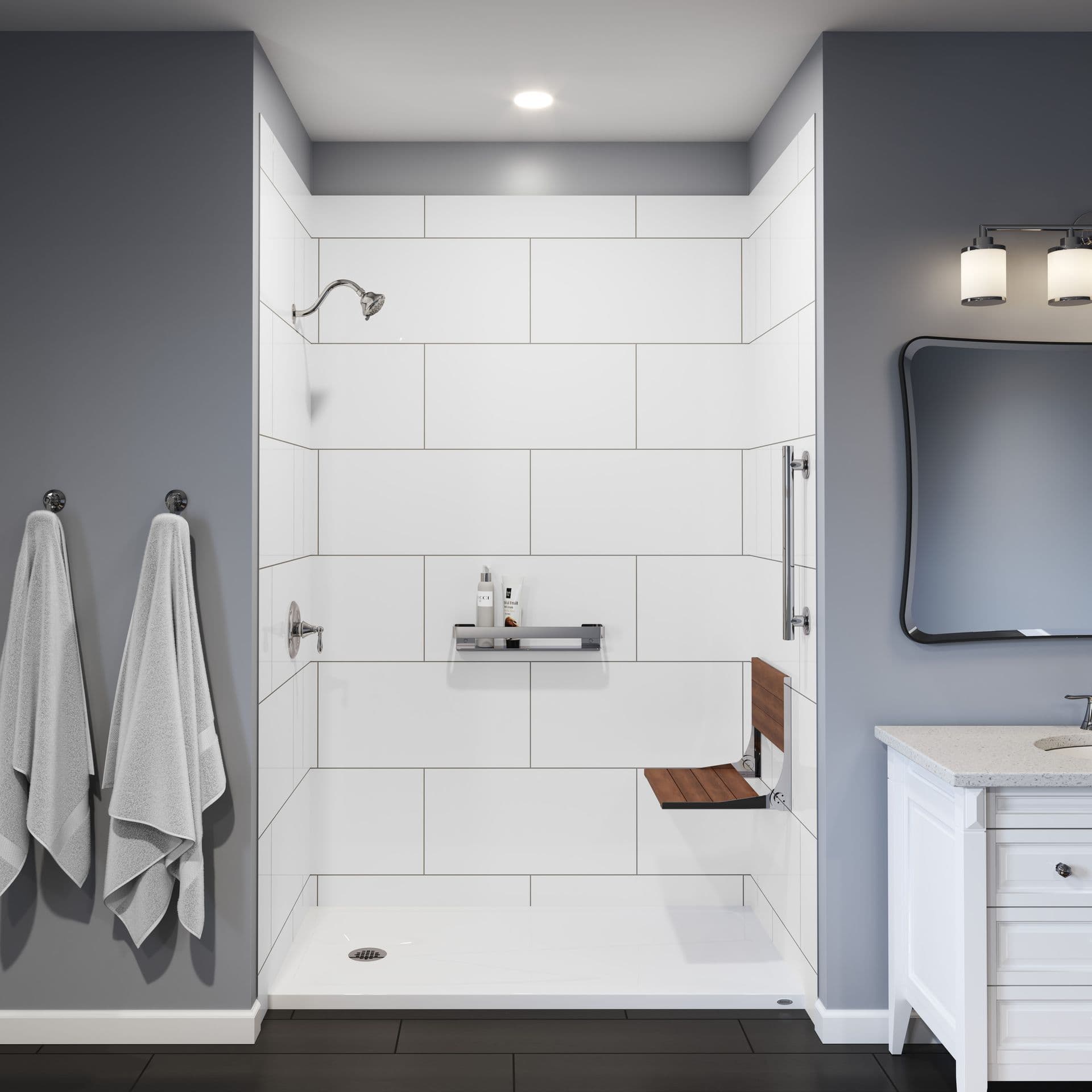 A gray bathroom with a walk-in shower with large white tile walls, folding shower bench, and a vertical grab bar.